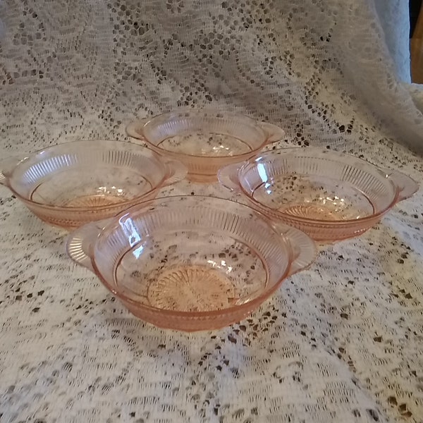 A set of 4 Coronation pink depression glass berry bowls that are 4.5" across the rim with tab handles taking it to 5.5".