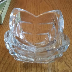May include: A clear glass bowl with a geometric design. The bowl is made of thick glass and has a square shape.