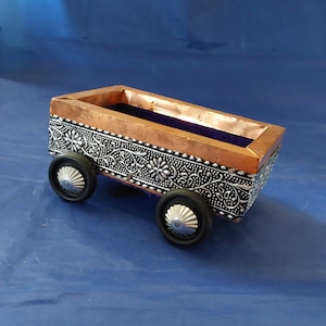 A hand made wooden crafted India designed cart with wheels, a purple velvet lining with a punched metal trim and copper trim.  Misc 1345