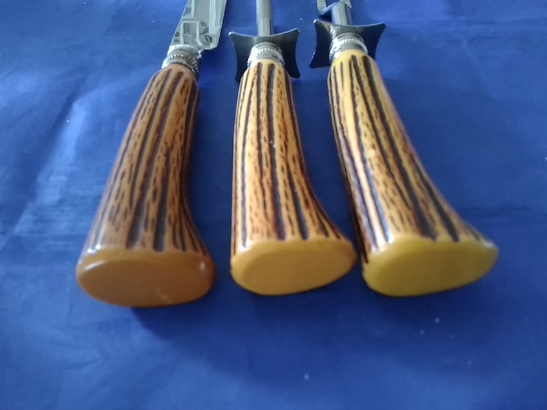 K&ouml;nnte beinhalten: Set aus drei Vintage-Steakmessern mit braunen und schwarzen Hirschhorn-Griffen. Die Griffe sind aus Kunststoff und haben eine gelbe Farbe.