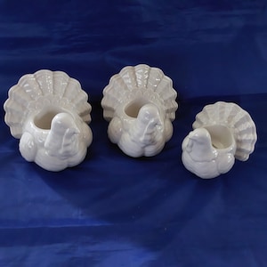 Three Yankee Candle white ceramic candle holders are turkeys.   The 2 large are for votive.  The smaller is for taper or votive.   Fall 15