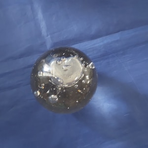 A 3 inch glass orb with a heart shaped center surrounded with floating bubbles paperweight.  Misc 1338