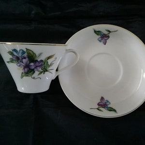 A matching porcelain cup and saucer with a violet pattern with gold trim from Japan.  CS 292