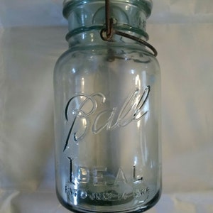 A blue 1933-1962 quart glass Ball Ideal canning jar with clear glass lid and bale wire closure.  Misc 859