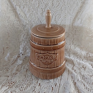 A 1950s McCoy Pottery 10.25" tall cookie jar in the form of a light brown wooden butter churn, labeled "Cookie Churn".  Canister 27