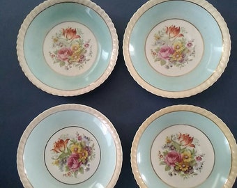 By Johnson Brothers Yeovil Old English a matching set of 4 ivory 5.74" saucers with a teal and floral design and a rope edge.  Dish 786