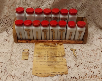 From the 1940s, by Griffiths, this is a copper and wood spice rack with 15 white milk glass bottles and red metal lids.  Misc 1958
