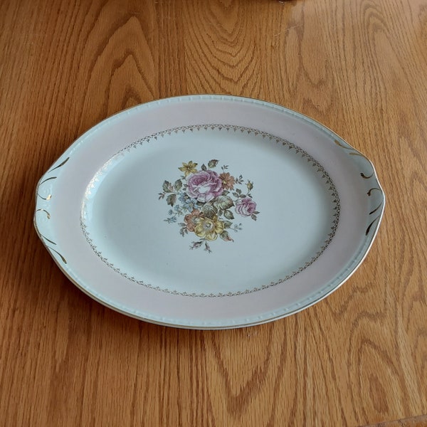 A 13 inch oval Homer Laughlin eggshell Georgian Arcadia patterned platter in pink trim, floral design and gold filigree.  HL 83