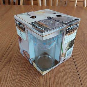 May include: A box of four Corelle Impressions glasses with a blue and white floral design. The glasses are made of tempered glass and are dishwasher safe.
