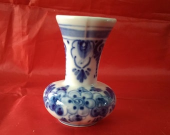 From Holland, a small white porcelain  vase with hand painted delph blue flower design.  Vase 271