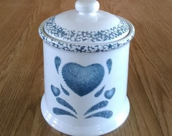 A Corelle white canister and rubber sealed lid, that is 7.25 inches tall , with blue sponge paint heart and trim by Jay Imports. Canister 29