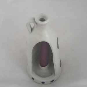 A marked Williamsburg Pottery, from Williamsburg Virginia, is a grey salt glaze pottery open candle holder with a cobalt blue design. SW 75