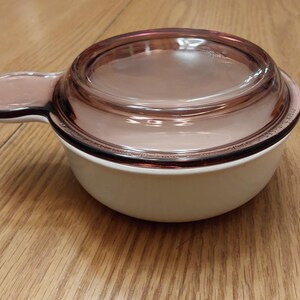 A white Grab-It casserole dish P-150-B and a purple Visions Grab-It glass lid.  CD 258