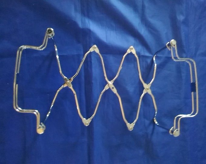 An Expandable Metal Trivet With Handles for a Casserole Dish That Will