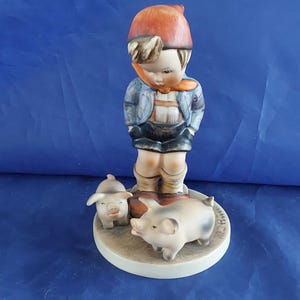 A vintage Farm Boy with Piglets-number 66, marked M J Hum on the top and "V" with a bee-W Germany blue backstamp 1960s. Misc 2051 image 1