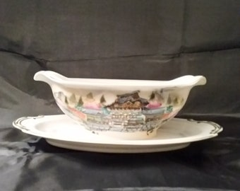 A Kutani hand painted porcelain gravy boat has a temple scene with Mt. Fiji in the background, highlighted and trimmed in gold.  DWS 207