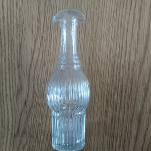 A Victorian Era clear glass cruet us vertically ribbed and  has a double spout.  This came in a cruet metal stand.  Dish 1504