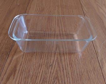 A Pyrex clear glass 8 " long loaf pan with handles. It is number 213 and made in the USA. CD 296