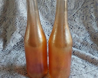 Stamped on the base, Canada Dry Gingerale Incorporated.  A set of 2-12 fl oz bottles are in an iridescent orange carnival glass.  Misc 2063