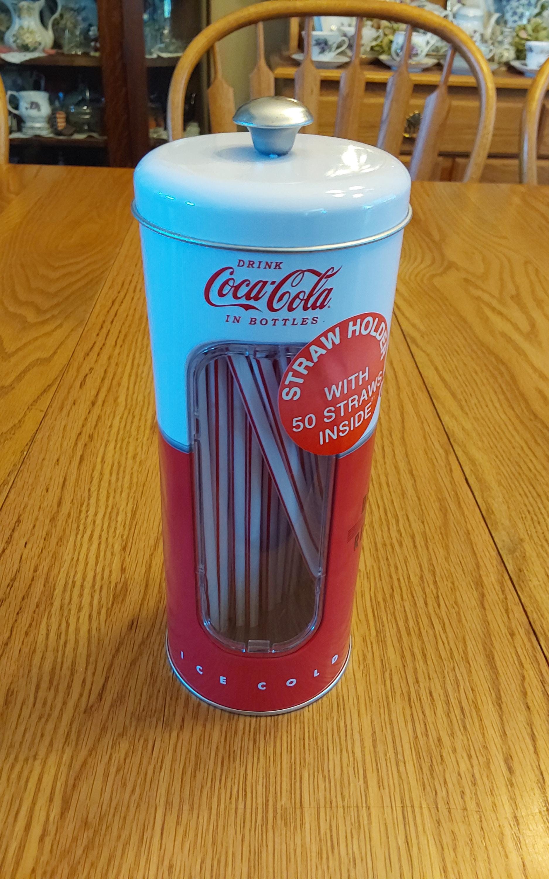 A Reproduction of a Metal White and Red Coca-cola Lidded Canister