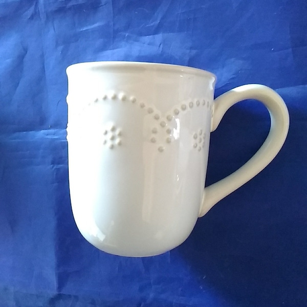 A 13 fluid ounce stoneware Food Network mugs in the Fontinella pattern in a white scalloped beaded design.  Glass 447