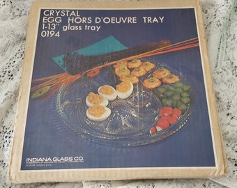 In original box, is a large round 13 inch Tiara Glass patterned clear glass that is a divided relish and deviled egg platter.  Tiara 198