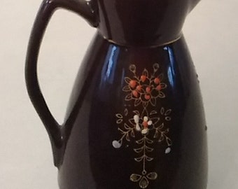 From Japan, a red clay brown pitcher with a Moraige design.  CS 202