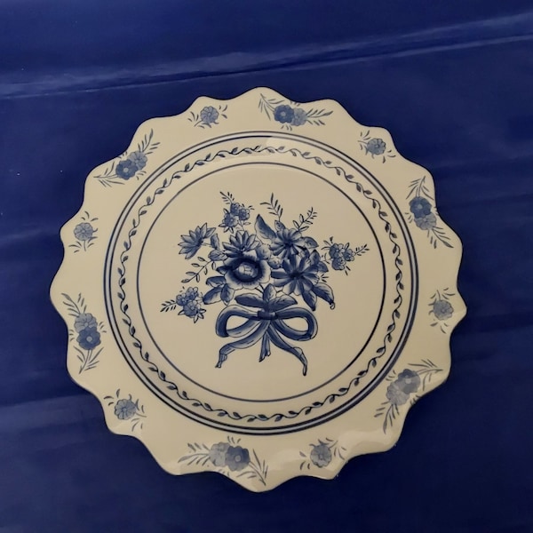A 12" white ceramic plate with a deep scalloped rim and a beautiful blue floral pattern with holes in the rim for wall hanging.  Plate 788