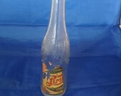 A 1940s Pepsi Cola wave logo bottle with a partial paper label. Misc 643