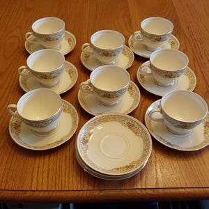 May include: A set of three ceramic mugs with a speckled, matte finish. The mugs are in shades of cream, light gray, and dark gray. Each mug has a simple, minimalist design and a rounded handle.