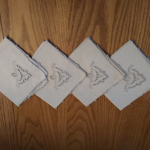 A set of 4 Ecru linen 11 inch square napkins with an embroidered trim surrounds each napkin and a design insert in one corner.  Misc 1202