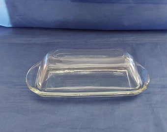 An Anchor Hocking clear glass butter stick dish with matching lid in a simple design, with no chips, cracks, or scratches.  Dish 1746