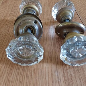A set of 2 antique interior 12 pointed glass door knob set with brass hardware.  Misc 2068