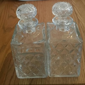A matching set of 2-20 oz glass decanter in a diamond pattern with matching ornate stopper.  Bar 778