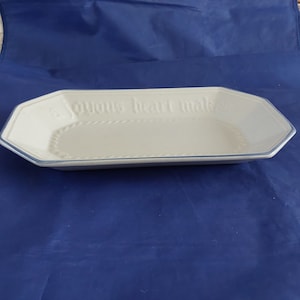 May include: A white rectangular serving dish with a blue rim and a raised inscription that reads "A joyous heart maketh a cheerful countenance".