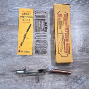 May include: A vintage rug tufting tool set. The set includes a metal and wood tufting tool, instruction sheet, and a box with the words "Speed Tufting Tool" printed on it. The instruction sheet is yellow with black text and illustrations.