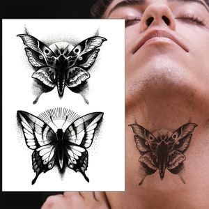 May include: Two black and white butterfly tattoo designs. The top butterfly has a more moth-like appearance with feathery antennae. The bottom butterfly has a more traditional butterfly shape with rounded antennae.