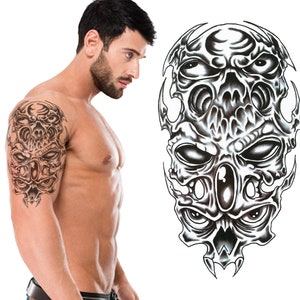 May include: Black and white temporary tattoo of a skull with multiple eyes. The tattoo is designed to be applied to the upper arm.