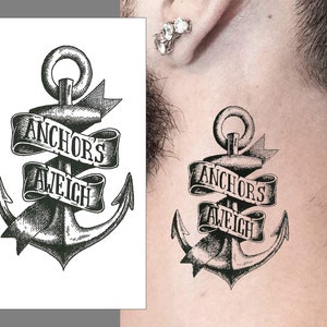 Pode incluir: Tatuagem temporária preto e branco de uma âncora com uma faixa que diz "Anchors Aweigh".