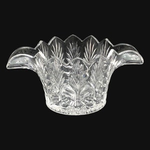 以下が含まれることがあります： 波打つ縁と2つの取っ手のある透明なガラスのボウル。ボウルはカットガラスのデザインです。