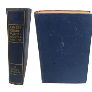 Op de afbeelding: Een blauw hardback boek met gouden letters op de rug. De titel is "LANGEN-SCHEIDTS TASCHEN-WÖRTER-BÜCHER" en de ondertitel is "II Deutsch Englisch".