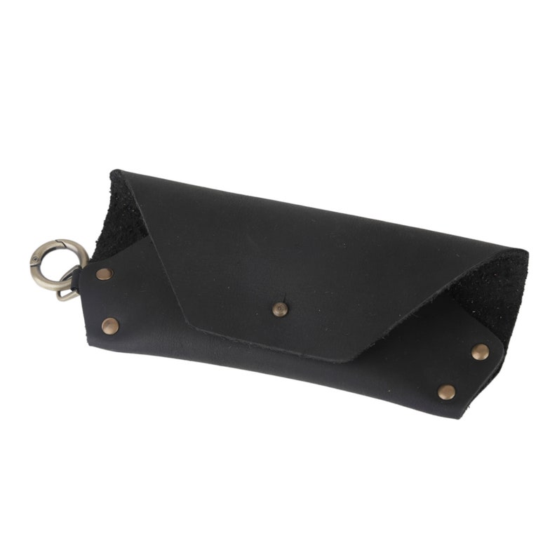 May include: Black leather glasses case with a metal clasp and rivets.