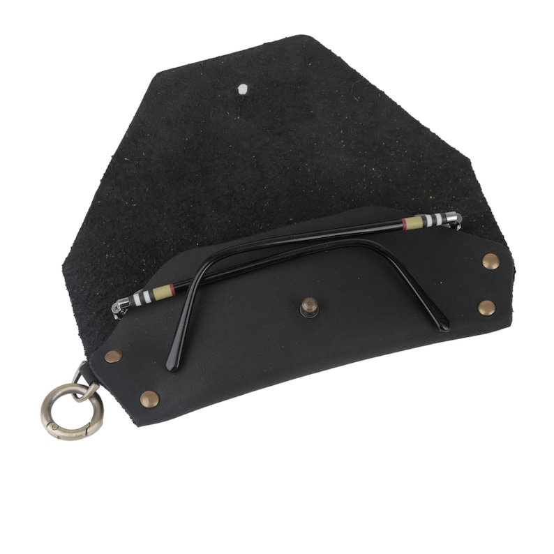 May include: Black leather glasses case with a snap closure and a metal ring. The case is open and a pair of black glasses with a striped pattern on the arms is inside.