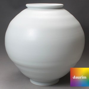 May include: A large, white ceramic vase with a rounded, bulbous shape. The vase has a smooth, glossy finish and a slightly flared rim.