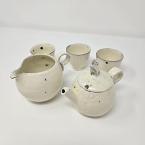以下が含まれることがあります： 斑点のある釉薬をかけた白い陶器のティーセット。セットには、蓋付きのティーポット、クリーマー、ティーカップ4個が含まれています。