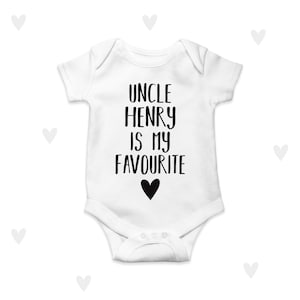Könnte beinhalten: Weißer Baby Strampler mit schwarzem Text, der "Onkel Henry ist mein Liebling" lautet, mit einem schwarzen Herzen unter dem Text.