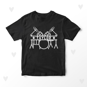 May include: Black t-shirt with a white outline of a drum set and the word "TAYLOR" in a banner above the drums.