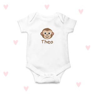 May include: White baby onesie with a brown monkey face and the name "Theo" embroidered on the front.
