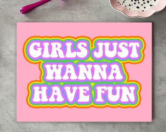 May include: Pink rectangular sign with the text "GIRLS JUST WANNA HAVE FUN" in white, outlined in rainbow colors. A pink spoon and a decorative plate with black dots are in the background.