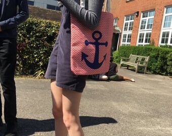 May include: A person carrying a pink and white tote bag with a blue anchor design. The bag has a chevron pattern.